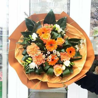 Buchet  rotund cu mixt de flori portocalii, ambalaj portocaliu