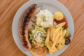 Salchicha Bratwurst Alemana con Ensaladas Alemanas y Papas Fritas 
