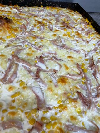 Pizza con prosciutto cotto, mais e mozzarella in teglia