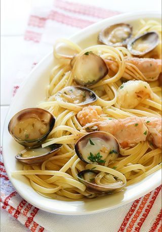 Linguine con scampi, olive tagliate, peperoncino e pomodorini