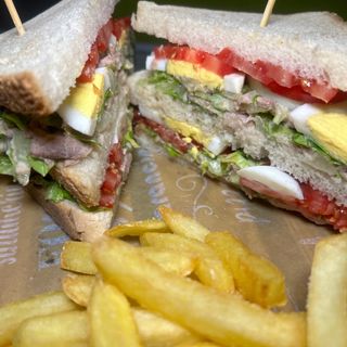 Tuna club servito con patatine fritte