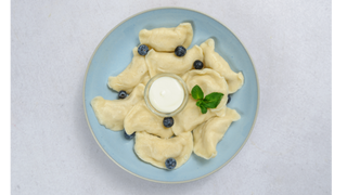 Pierogi z jagodami ze śmietaną i cukrem