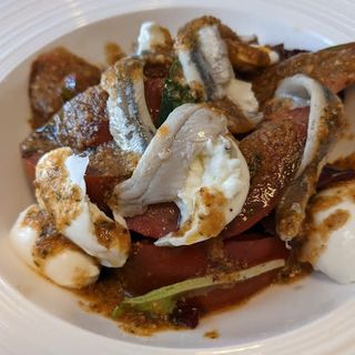 Ensalada de tomate con burrata con boquerones y pesto rojo