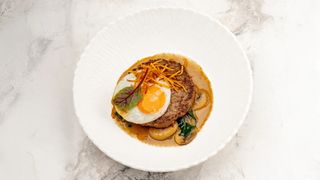 Большая жаренная котлета из мрамор говядины на подушке из шпината и грибов 