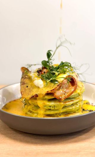 Spinach pancakes  with bacon and poached egg and hollandaise sauce