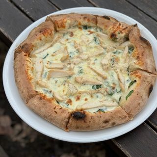 Піца з куркою, шпинатом, моцарелою та пармезаном 