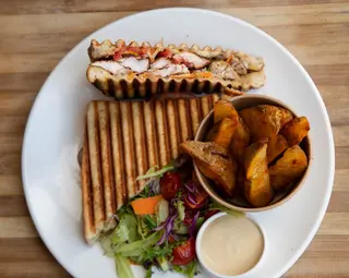 Thai Basil Chicken Sandwich with fried potato wedges, garden salad and garlic mayo.