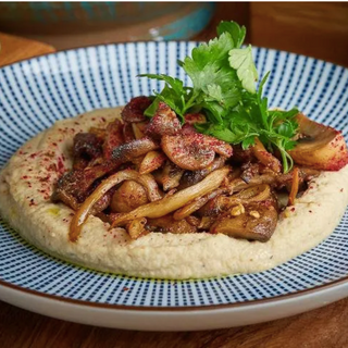 Печериці з карамелізованою цибулею на подушці з хумусу