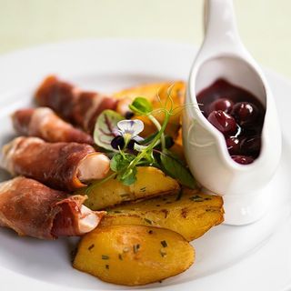 Piept de pui invelit in prosciutto, cartofi cu rozmarin, sos de visine