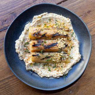 Puerros a la brasa con cama de Hummus