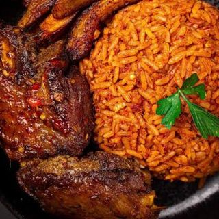 Jollof rice served with plantains and peppered turkey and a can of Palm Wine