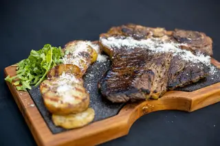 T-bone cu cartofi pe plită