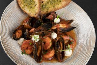 Mix de fructe de mare in sos rosu si paine cu pesto