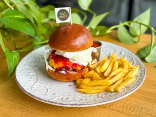 Burger z wołowiną, sosem serowym i wiśniami frytkami i ketchupem