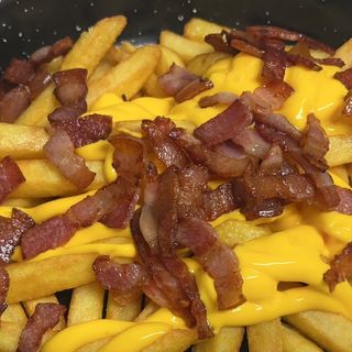 Cazuela de patatas fritas con salsa cheddar y bacon crujiente  