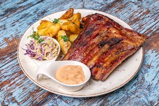 Coaste de porc la jar cu cartofi prajiti, salata coleslaw si sos roze