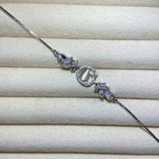 Srebrena narukvica sa sedefastim kamenom unutar kruga i kristalima okolo