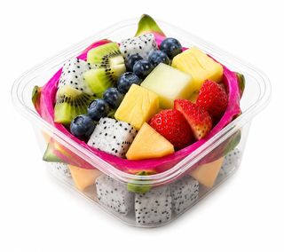Frutta vivid color con ananas, kiwi, fragole, pitaya, mirtilli e melone