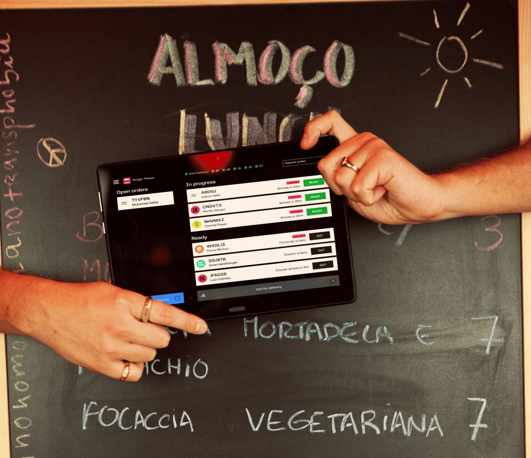 A person passes tablet displaying Kitch website to another