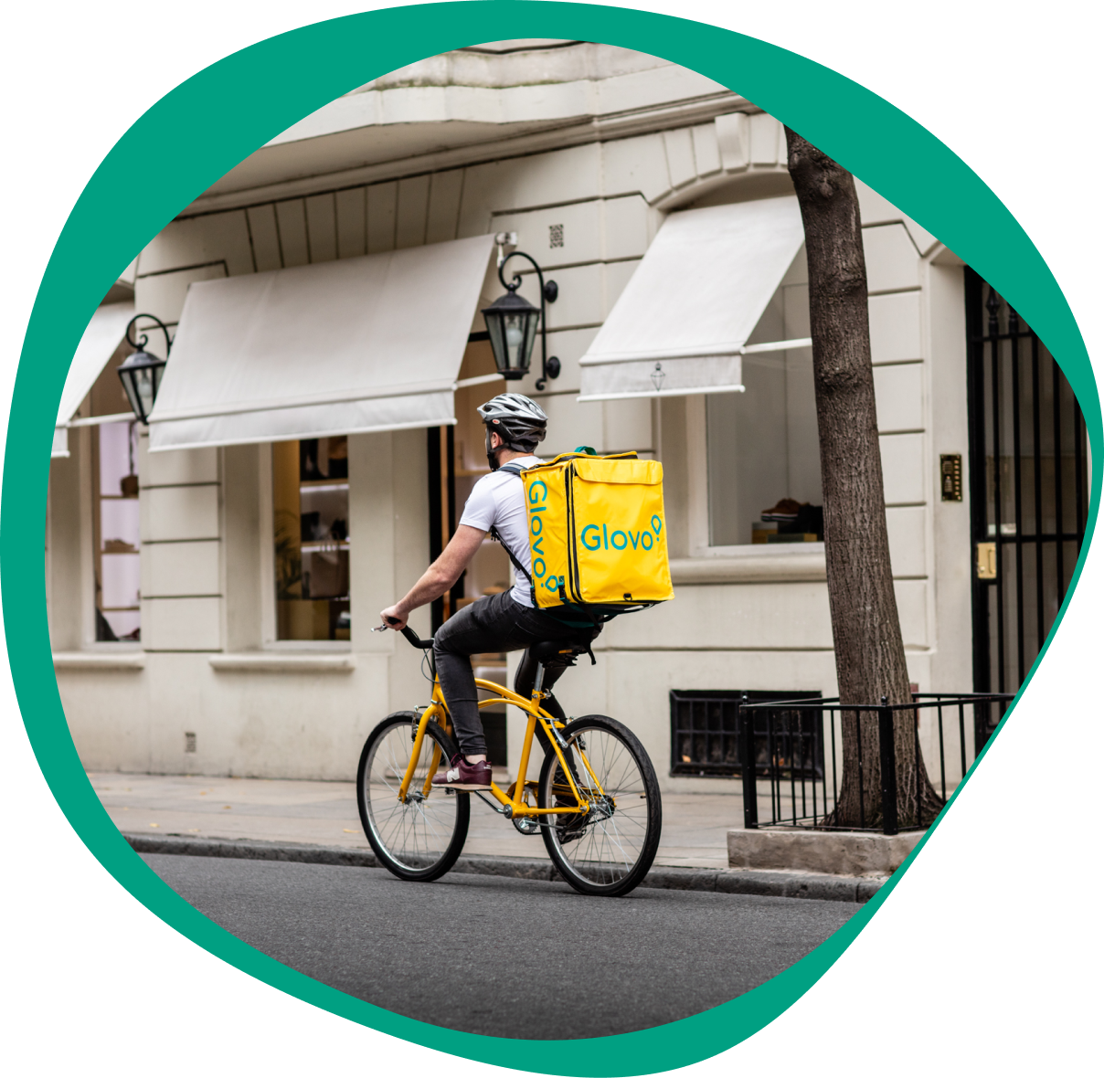 A Glovo courier cycling down the street