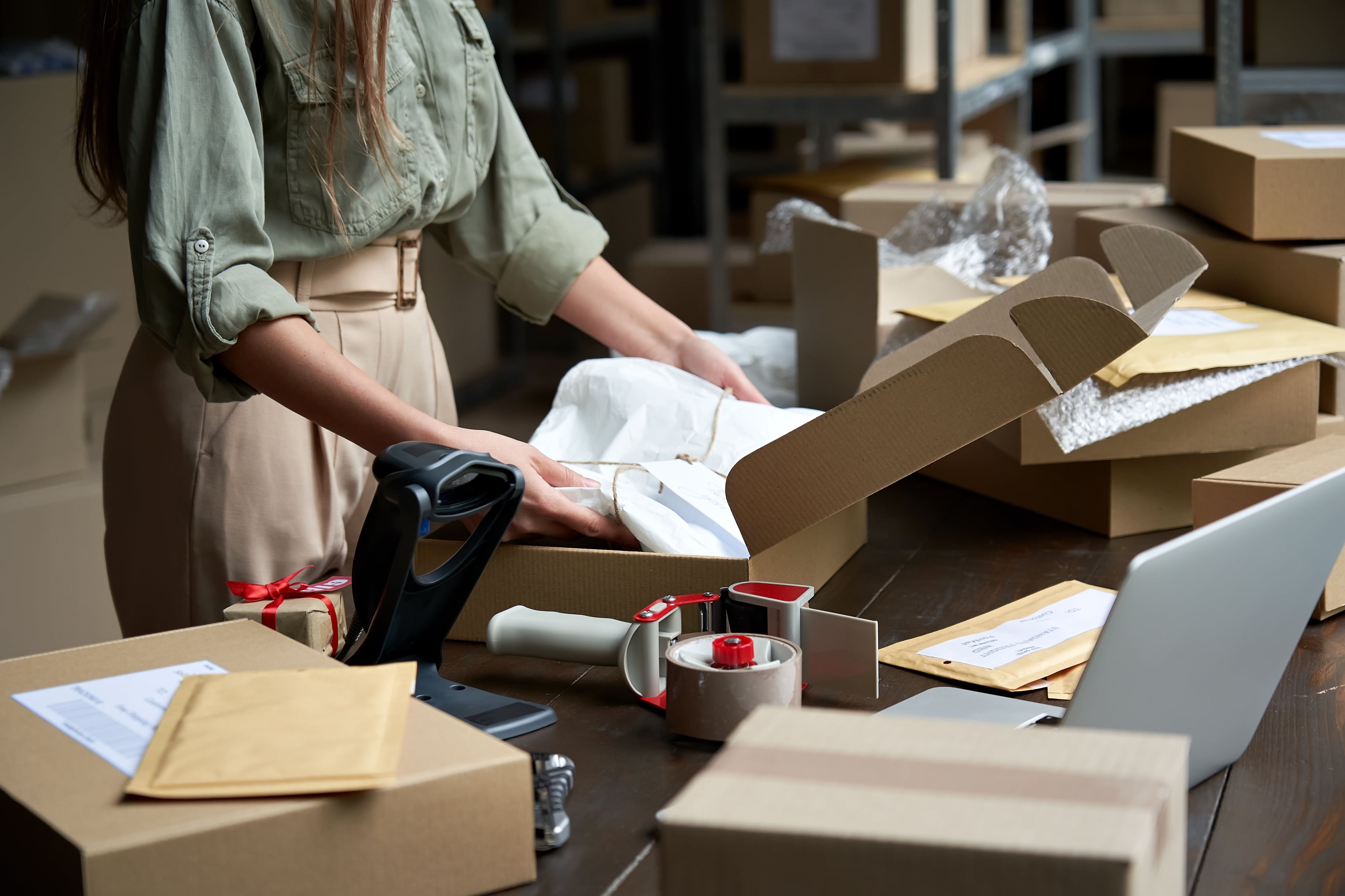 Woman packing orders into delivery boxes
