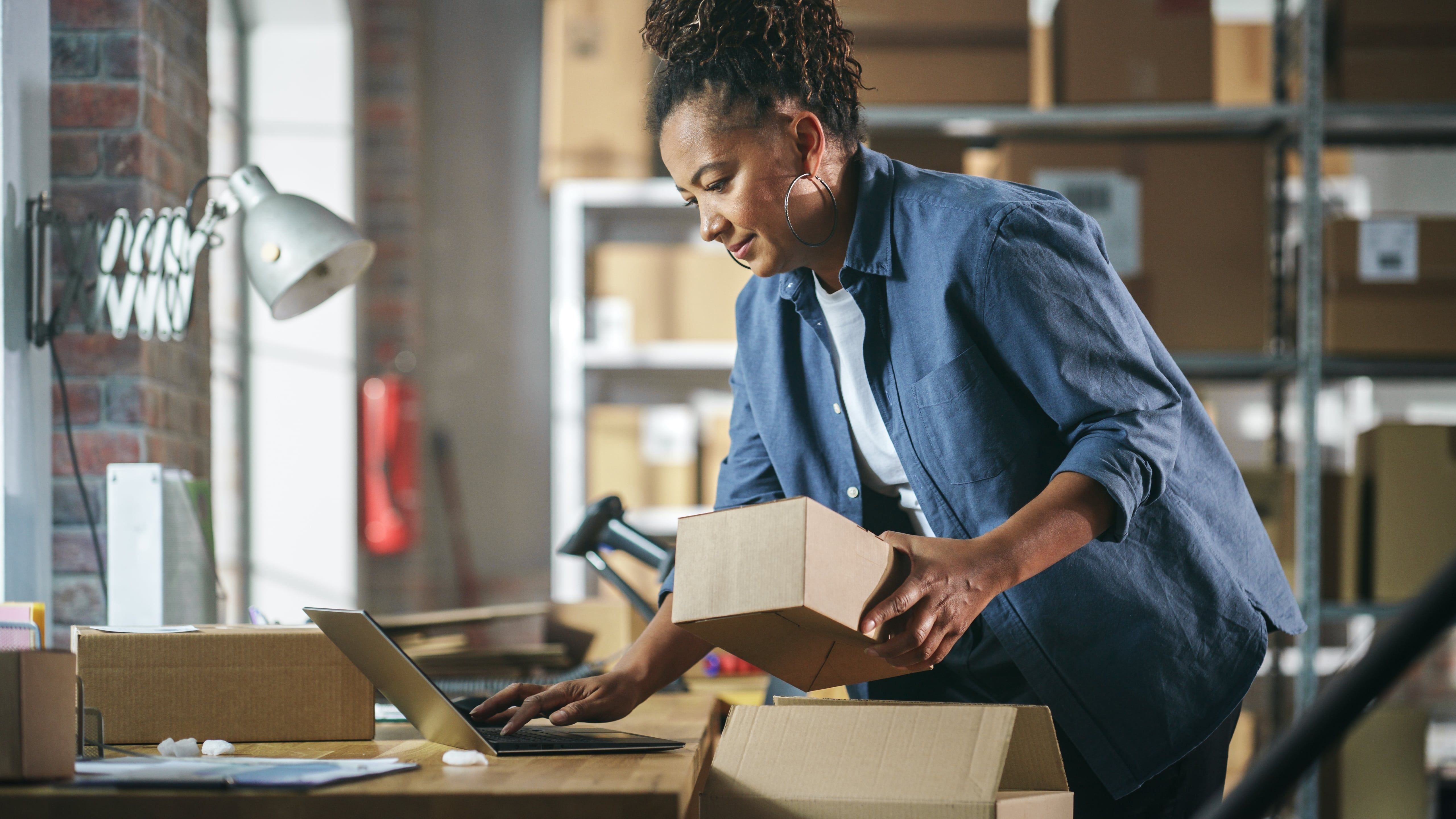 Woman packing orders into delivery boxes