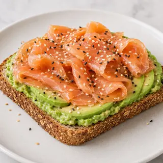 Tostada De Aguacate + Salmón + Semillas De Sésamo