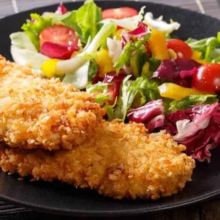 Cotoletta di pollo con patate e insalata