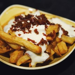 Patatine fresche fritte con fonduta di cacio e pepe e bacon