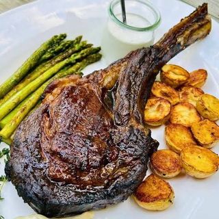 Tomahawk de porc cu cartofi cu branza si ou ochi